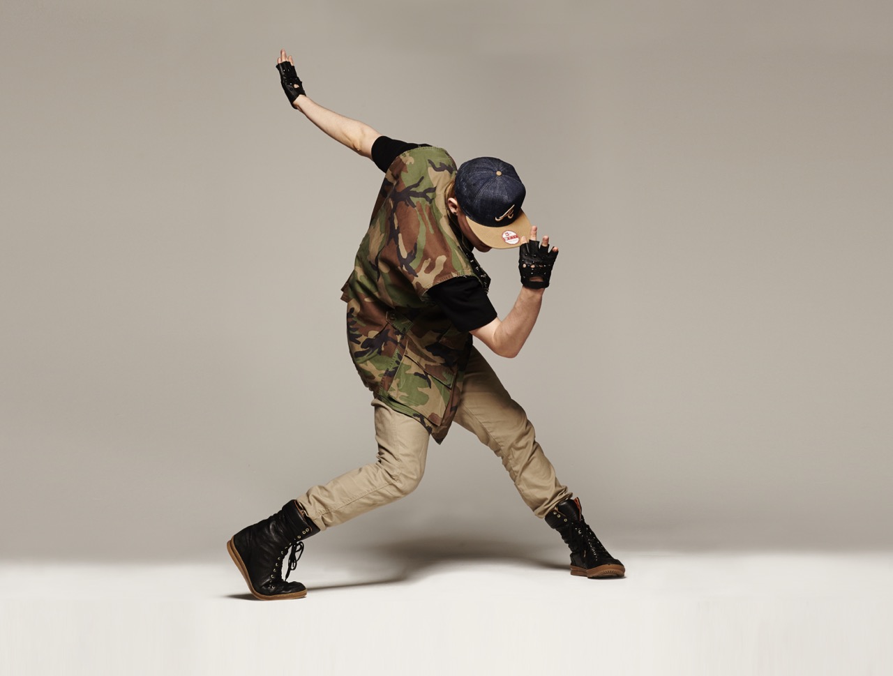 A dancer captured mid-performance, arm extended, in the studio